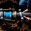 Photo of a sewer contractor working on a pipe by asterix0597/istockphoto.com.