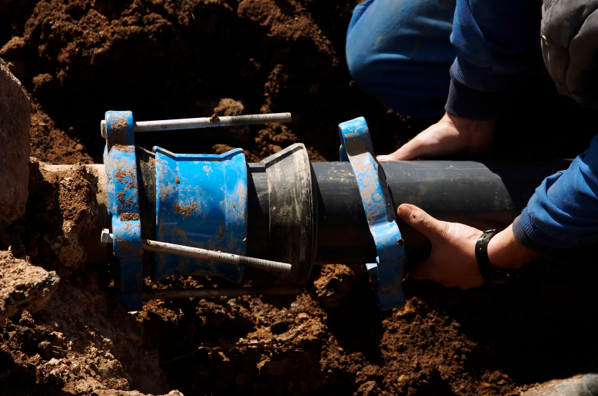 Photo of a sewer contractor working on a pipe by asterix0597/istockphoto.com.