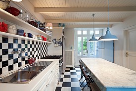 Photo of a black and white tiled kitchen in a luxury apartment by piovesempre/istockphoto.com.