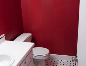 DIY striped bathroom walls in shades of red. Photo by Sayward Rebhal.