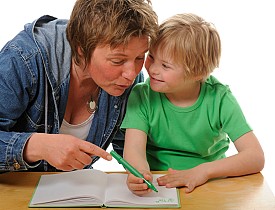 A mom helps a child with Down's Syndrome with homework. (Photo: EVAfotografie/ istockphoto.com)