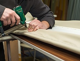 Photo of an upholsterer using an upholstery gun by AzmanL/istockphoto.com.