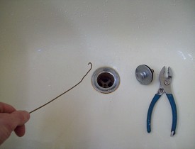 Here I am, goin' fishin' with a coat hanger. It's one DIY way to unclog a bathtub drain. --Phil