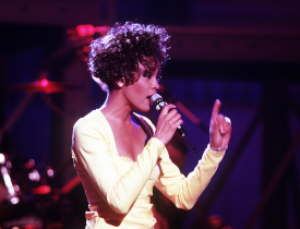 Whitney Houston performing for US troops in a televised concert. [Photo via Wikimedia Commons]