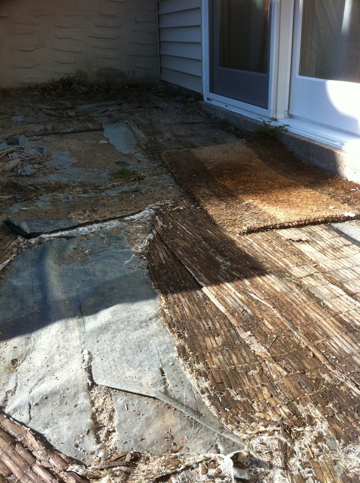 This is the patio now: bamboo mats are covering landscaping plastic and sand.