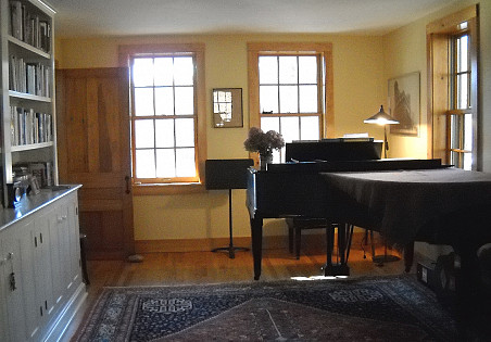 The Brydens split a long, narrow space into a music room and a sitting room. Their grand piano is not at all out of place in their farmhouse.
